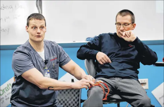  ?? AP PHOTO/CHARLIE NEIBERGALL ?? In this photo, trauma care specialist Brian Feist and Dr. Richard Sidwell lead a medical training session for teachers and sta  at Southeast Polk High School in Pleasant Hill, Iowa. With school shootings a regular occurrence, educators across the...