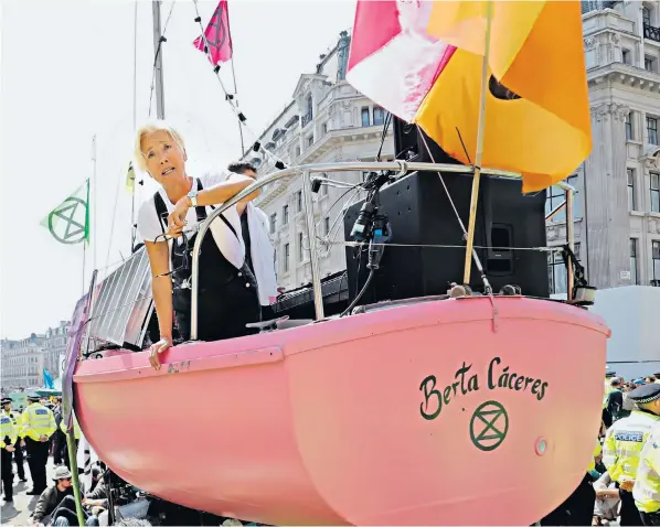  ?? ?? Emma Thompson perches on a boat being used as a stage during Extinction Rebellion protests in London. The actress accused Shell of pursuing a ‘callous’ £1.7m case against Greenpeace