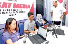  ??  ?? Gobind (standing) during his visit to the Sandakan parliament­ary by-election media centre at the Community College yesterday.