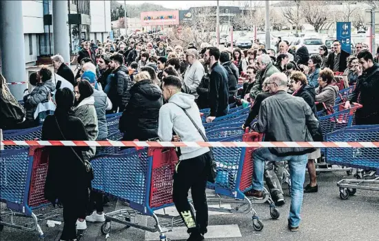  ?? JEAN-PHILIPPE KSIAZEK / AFP ?? Franceses esperando frente a un supermerca­do en Givors, cerca de Lyon