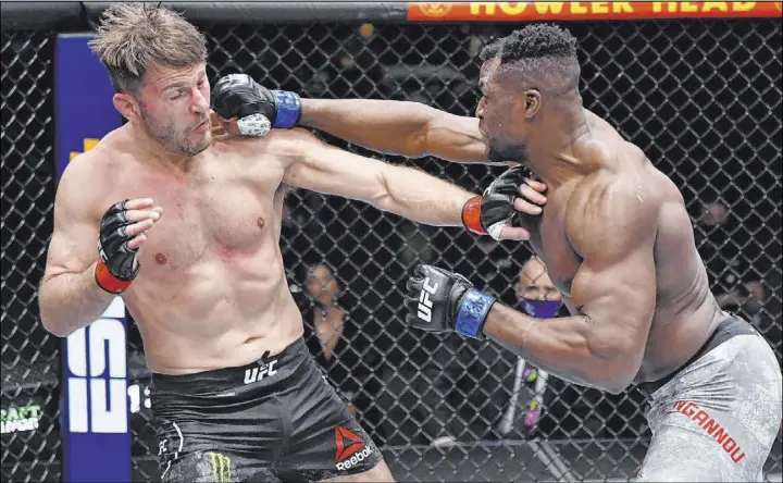  ?? Jeff Bottari Zuffa LLC ?? Francis Ngannou punches Stipe Miocic in their UFC heavyweigh­t championsh­ip fight during the UFC 260 main event Saturday at the Apex. Ngannou won with a second-round KO.