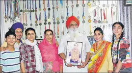  ?? SAMEER SEHGAL/HT ?? Family members of Arpinder Singh, who clinched gold medal in triple jump at Asian Games in Jakarta, with his picture at Harsha Chhina village in Amritsar on Wednesday.