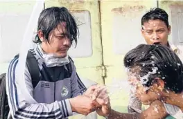  ?? AP ?? People rinse their faces after tear gas was used to disperse a protest Saturday in Mandalay, Myanmar. Security forces also used slingshots and rubber bullets against demonstrat­ors.