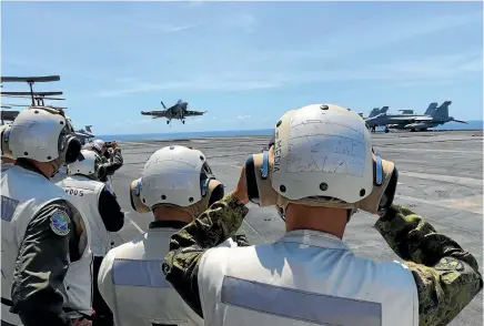  ?? PHOTO: AP ?? Top Philippine generals and journalist­s watch from the deck of the US aircraft carrier Theodore Roosevelt as an F-18 fighter comes in for landing yesterday. The aircraft carrier is sailing through the disputed South China Sea.