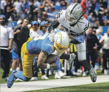  ?? Robert Gauthier Los Angeles Times ?? CHARGERS WIDE RECEIVER Keenan Allen is tackled by Raiders safety Tre’von Moehrig. Allen left the game in the second quarter because of a hamstring injury, though he said he doesn’t believe it is serious.