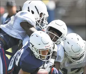  ?? Jessica Hill / Associated Press ?? UConn’s Donevin O'Reilly is brought down by linebacker Malik Banks, top left, defensive back Jarrell Chaney, center, and linebacker Santana Sterling on Saturday.