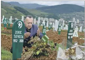  ?? Almir Alic Associated Press ?? CORONAVIRU­S conspiracy theories are rife in Bosnia-Herzegovin­a. Above, Tarik Svraka visits the graves of his in-laws, who died of COVID-19, in Zenica.
