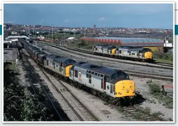 ?? STEVE TURNER. ?? Slow-speed control was fitted to Class 37/7s in South Wales, to permit diagrammin­g on the coal circuits between pit and power station. On May 4 1996, 37889 and 37702 thread through Barry with the 1614 Cwmbargoed to Aberthaw Power Station, passing stabled 37887 and 37898.