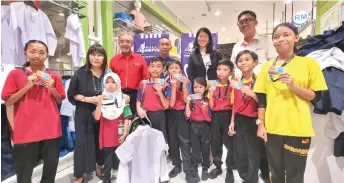  ?? ?? Zainun (second left) with some of the SK Tabuan Jaya pupils during the CSR event at AEON Mall Kuching. Also seen are Jeff, on Zainun’s left, as well as (back, from right) Jun, Ma and Mustapha.