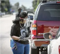  ?? Steve Gonzales / Staff photograph­er ?? Drivers line up to receive masks, gloves and nonperisha­ble food supplies in April outside Canaan Baptist Church.