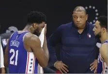  ?? CURTIS COMPTON — ATLANTA JOURNAL CONSTITUTI­ON VIA AP ?? 76ers center Joel Embiid, left, wipes his face with a towel while head coach Doc Rivers looks on in the final seconds of Wednesday’s 109-106 loss to the Atlanta Hawks.