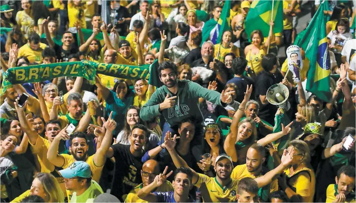  ?? PHOTO AFP ?? Des partisans de Jair Bolsonaro se sont rassemblés devant le Congrès national à Brasilia pour célébrer la victoire de l’ex-capitaine de l’armée connu pour ses propos-chocs.
