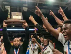  ?? Lucy Schaly/Post-Gazette ?? Imani Christian coach Omar Foster and his players celebrate their Class 1A title Thursday.