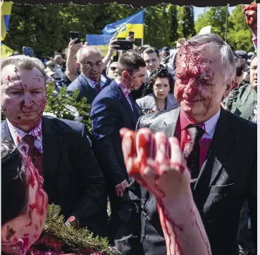  ?? PHOTO AFP ?? L’ambassadeu­r russe Sergueï Andreev a été arrosé par une substance liquide rouge hier au cimetière de Varsovie en Pologne en marge de célébratio­ns.