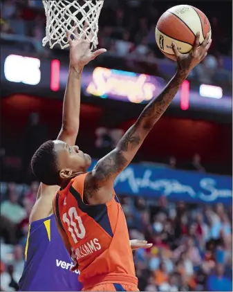  ?? SEAN D. ELLIOT/THE DAY ?? Connecticu­t Sun guard Courtney Williams scores on a reverse layup around Los Angeles Sparks forward Candace Parker in the second half of Sunday’s game at Mohegan Sun Arena.