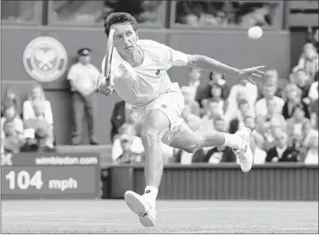  ?? ALASTAIR GRANT/ASSOCIATED PRESS ?? Sergiy Stakhovsky returns to Roger Federer during their second-round match on Wednesday at Wimbledon. Stakhovsky beat the defending champion in four sets to pull a massive upset.