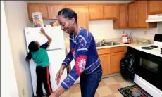  ?? John Heller/Post-Gazette ?? Ahmaree and his mother, Ashona, make snacks after work at their apartment in East Hills.