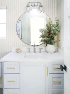  ??  ?? |TOP RIGHT| HIP AND COOL. The daughter’s bathroom features a dynamic Joanna Gaines wallpaper and ties in with the chandelier in the bedroom. “I like everything to flow...not overly match,” Mindy says. “Here, the soft gray paint adds a touch of femininity and the contempora­ry brass hardware keeps it hip and cool.”