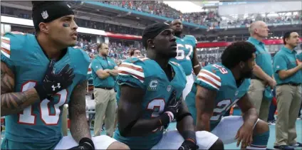  ??  ?? In this Oct. 23, 2016, file photo, Miami Dolphins wide receiver Kenny Stills (10), free safety Michael Thomas (31) and defensive back Chris Culliver (29) kneel during the National Anthem before the first half of an NFL football game against the Buffalo...