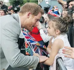  ?? BEN BIRCHALL/PA VIA THE ASSOCIATED PRESS ?? Prince Harry greets a young well-wisher during a walkabout with Prince William outside Windsor Castle, in Windsor, England on Friday.