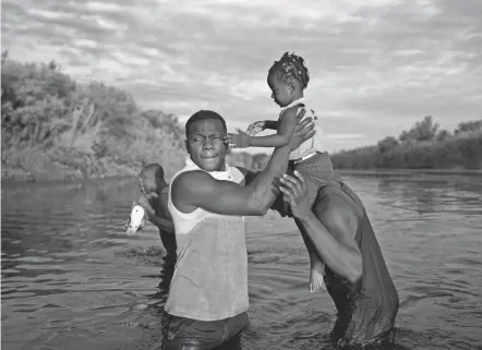  ?? FERNANDO LLANO/AP ?? Men carry a girl across the Rio Grande on Wednesday as migrants leave Del Rio, Texas, to return to Ciudad Acuna, Mexico. Two U.S. officials say many migrants are being released in the United States.