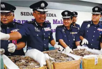  ?? ASHRAF SHAMSUL/ THE SUN ?? Abdul Wahabi (second left) showing some of the boxes full of scales found at the KLIA Mail and Courier Centre.