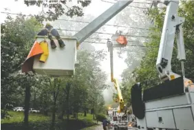  ?? STAFF PHOTO BY DOUG STRICKLAND ?? Linemen with EPB work to restore power Tuesday in Signal Mountain. After Hurricane Irma devastated Florida, the storm’s remnants brought heavy rains and high winds to the region.