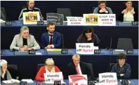  ?? VINCENT KESSLER/REUTERS ?? SUARA POLITIK: Anggota parlemen Uni Eropa memasang plakat yang menolak serangan sekutu ke Syria saat Macron berpidato kemarin.
