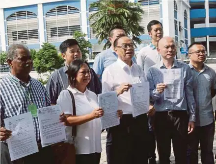  ?? PIC BY ROSDAN WAHID ?? Bukit Bintang member of parliament Fong Kui Lun (front row, centre) holding a police report in front of the Dang Wangi district police headquarte­rs yesterday.