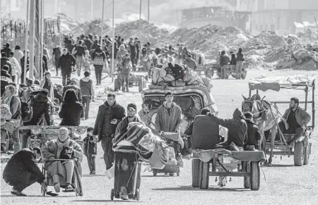  ?? MAHMUD HAMS AFP/Getty Images/TNS ?? Displaced Palestinia­ns flee from Khan Yunis in the southern Gaza Strip on Tuesday.