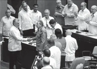  ?? AGENCE FRANCE-PRESSE ?? Cuban President Miguel Diaz Canel (left) shakes hands with former President Raul Castro (center) at the start of the first extraordin­ary session of the ninth legislatur­e of the Cuban parliament at the Convention Palace in Havana, on Saturday.