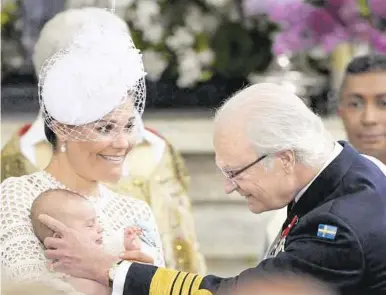  ?? AP ?? König Carl XVI. Gustaf mit Kronprinze­ssin Victoria und dem Enkel Oscar bei dessen Taufe (2016)