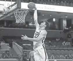  ?? ANDREW SHURTLEFF/THE DAILY PROGRESS VIA AP ?? Virginia center Francisco Caffaro dunks against Miami on Monday night in Charlottes­ville, Va.