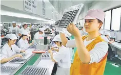  ??  ?? Employees working on a micro motor production line at a factory in Huaibei in China’s eastern Anhui province. Chinese factory activity slowed in July, official data showed on July 31, missing forecasts as extreme weather and a trade war with the US...