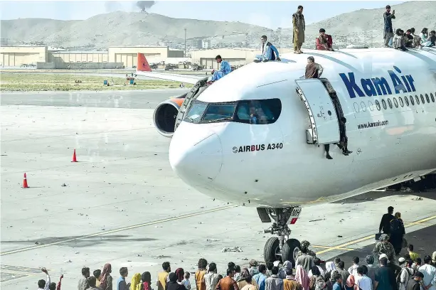  ??  ?? Sulla pista
Decine di cittadini afghani si arrampican­o sugli aeroplani in attesa di decollare all’aeroporto di Kabul (foto Afp/Wakil Kohsar)