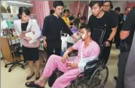  ?? QIN QING / XINHUA ?? Friends return survivor Huang Junxiong to his ward in Phuket on Sunday.