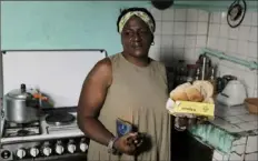  ?? ?? María de los Ángeles Pozo, a retired schoolwork­er, holds some of the subsidized food she receives through a government ration book known as a “libreta,” in Havana.