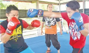  ??  ?? USTAZ Gusniah sedang melatih pergerakan Samir dan Samuel dalam sesi latihan tinju di Kompleks Sukan Sandakan.