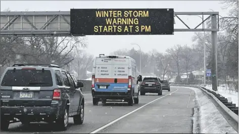  ?? TRISHA AHMED/AP ?? VEHICLES PASS A SIGN that reads “WINTER STORM WARNING STARTS AT 3PM” along Interstate Highway 35 near the Minneapoli­s-saint Paul Internatio­nal Airport in Minn., on Tuesday ahead of a winter storm that took aim at the Upper Midwest.