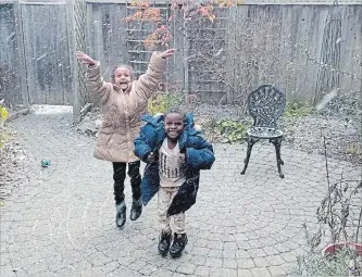  ?? HO-REBECCA DAVIES THE CANADIAN PRESS ?? A screengrab from video shows two Eritrean children reacting gleefully to their first Canadian snowfall.