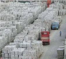  ?? /Reuters/File ?? Expanse of aluminium:
Big stacks of aluminium ingots loom over a worker and trucks at a depot in Wuxi, China's Jiangsu province. LME headline aluminium volumes rose 34% in January-April,