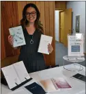  ??  ?? Maria Fitzgerald, owner of One Ray Journal, shows a collection of her daily affirmatio­n and gratitude journals.