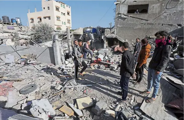  ?? ?? CONFLICT: Palestinia­ns inspect the damage caused to residentia­l buildings following Israeli strikes on Dair El-Balah in the centre of the Gaza Strip.