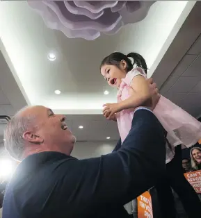  ?? DARRYL DYCK/THE CANADIAN PRESS ?? NDP Leader John Horgan, left, picks up Gabrie Man, 2, during a stop in Surrey on Monday as the election campaign nears its end.