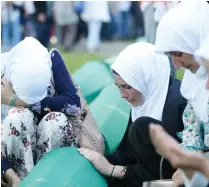  ?? — AP ?? Bosnian Muslim women react near the coffin of one of the 35 identified victims of the 1995 massacre, at the memorial centre of Potocari near Srebrenica on Wednesday.