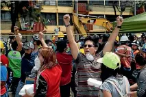  ??  ?? People motion to others to be quiet as rescue workers are searching for survivors under the rubble of a collapsed building in Mexico City.