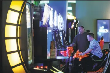  ?? Cindy Schultz / Albany Times Union ?? Customers play games at Dave and Buster’s restaurant in Guilderlan­d, N.Y. The chain is getting ready to open its newest location in Milford.