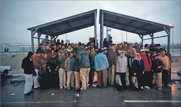  ?? ODED BALILTY / AP / ARCHIVO ?? Trabajador­es palestinos de Cisjordani­a en un puesto fronterizo israelí esperando autobuses para ir a trabajar