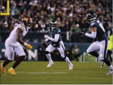  ?? MATT SLOCUM — THE ASSOCIATED PRESS ?? Philadelph­ia Eagles quarterbac­k Jalen Hurts, center, scrambles during the second half against the Washington Commanders on Monday night at Lincoln Financial Field.