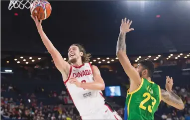  ?? The Canadian Press ?? Canada’s Kelly Olynyk, left, goes up to the rim as Brazil’s Augusto Lima defends during FIBA World Cup qualifying action in Laval, Que., on Thursday. Canada won 85-77.